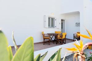 a patio with a table and chairs in a room at Tsakanos Apartments in Adamantas