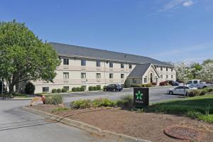 Extended Stay America Suites - Knoxville - West Hills في نوكسفيل: مبنى ابيض كبير امامه لافته