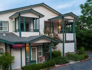 a white house with green accents at Grass Valley Courtyard Suites in Grass Valley