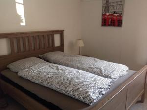 a bed with two pillows on it in a bedroom at Klitgaards Holiday Apartment in Mejeriby