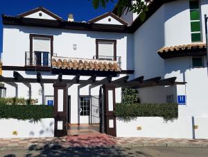 een wit huis met een veranda en een balkon bij Albenzaire Hotel Asador in Fuensanta