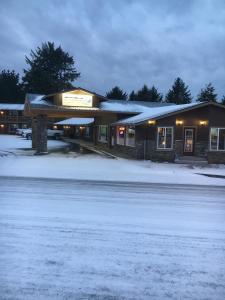 a building with snow on the ground next to a street at The Waldport Inn in Waldport