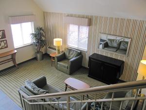 Extended Stay America Select Suites - Greenville - Haywood Mall في غرينفيل: غرفة معيشة بها أريكة وتلفزيون