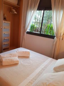 um quarto com duas toalhas numa cama com uma janela em Lydia´s House em Comarruga