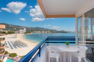 a balcony with a table and chairs and a beach at Apartamentos Calablanca in Palmanova