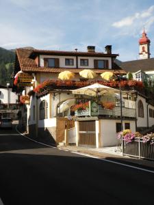 um edifício com flores ao lado de uma rua em Gasthof Moarwirt em Colle Isarco