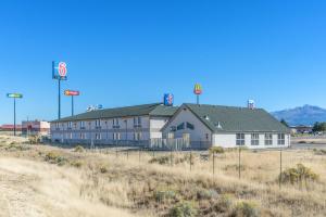 a large white building in the middle of a field at Motel 6-Beaver, UT in Beaver