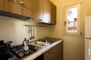 eine kleine Küche mit einer Spüle und einem Herd in der Unterkunft La Corte dei Mille in Presicce