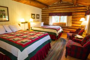 ein Hotelzimmer mit 2 Betten und einem Stuhl in der Unterkunft Jenny Lake Lodge in Beaver Creek