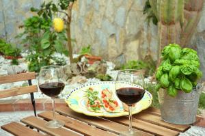 two glasses of wine and a plate of food on a table at B&B Cetara Amalfi Coast in Cetara