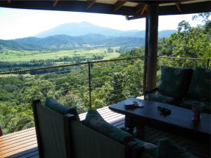 a balcony with chairs and a table and mountains at Cloud 9 in Daintree