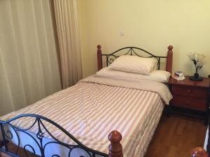 ein Schlafzimmer mit einem Bett und einer Kommode mit einem Kissen in der Unterkunft San Stefano Grand Plaza in Alexandria