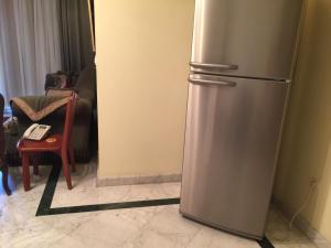 einen Kühlschrank aus Edelstahl im Wohnzimmer in der Unterkunft San Stefano Grand Plaza in Alexandria