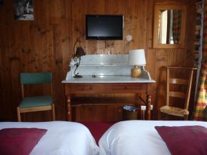 a hotel room with a bed and a tv at Les Glières - Champagny-en-Vanoise in Champagny-en-Vanoise