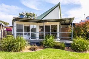 a small house with a wrap around porch at A River Bed Cottage in Aireys Inlet