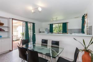 a dining room with a glass table and chairs at A River Bed Cottage in Aireys Inlet