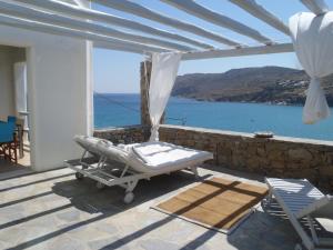 a bed on a patio with a view of the ocean at Sea Side Studios & Houses in Kalo Livadi