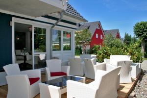 a group of white chairs on a patio at Pension Amo Marem in Dierhagen