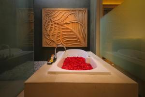 a bathroom with a tub filled with red beads at The Jineng Villas by Ekosistem in Seminyak