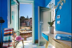 een blauwe kamer met een bureau en een raam bij Estate4home - La Grotta Azzurra in Sorrento