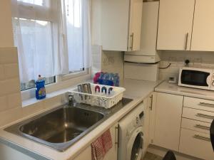 a kitchen with a sink and a washing machine at Abbey Wood Station six Bedroom Self Contained House in Abbey Wood