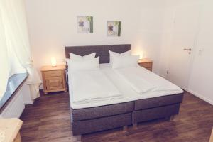 ein Schlafzimmer mit einem großen Bett mit zwei Nachttischen in der Unterkunft Hotel Garni Reis in Treis-Karden