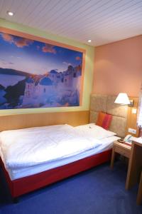 a bedroom with a bed with a painting on the wall at Hotel Vivendi in Herford
