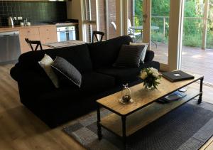 a living room with a black couch and a coffee table at Indulge at Daylesford in Daylesford