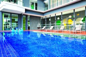 a large swimming pool with chairs and tables in a building at ST Residences Novena in Singapore