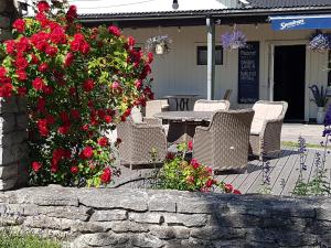 a patio with chairs and a table with red flowers at Tofta Bed & Breakfast in Tofta