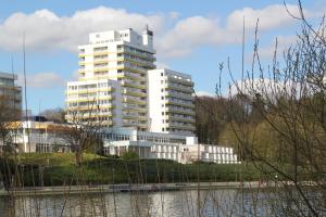 un edificio blanco alto junto a un cuerpo de agua en Seeblick Bad Segeberg, en Bad Segeberg