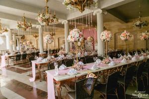 a long table in a room with pink flowers at Villa Arte Hotel in Vladivostok