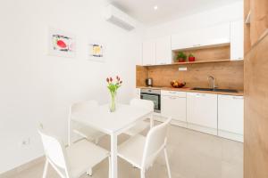 a white kitchen with a white table and chairs at Urban Chic LUXE apartments near Beach Bačvice & CENTRE in Split