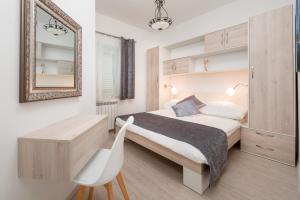 a bedroom with a bed and a mirror and a chair at Urban Chic LUXE apartments near Beach Bačvice & CENTRE in Split