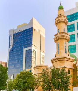 a building with a clock tower in front of a building at Executive Suites Abu Dhabi in Abu Dhabi