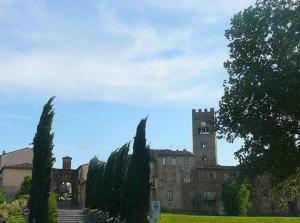 a building with a tower and a bunch of trees at Cavalieri del Tau in Altopascio