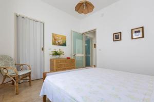 プンタ・プロシュートにあるSerra degli Angeli by BarbarHouseの白いベッドルーム(ベッド1台、椅子付)