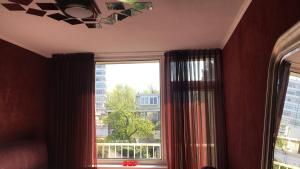 een kamer met een raam met uitzicht op de stad bij Sunny Guesthouse in Amsterdam
