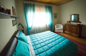 a bedroom with a bed and a window with blue curtains at dalla manu in Treviso