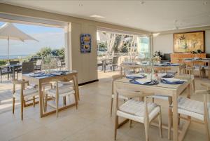 un comedor con mesas y sillas y un patio en Abalone Guest Lodge en Hermanus