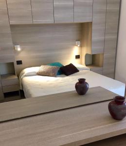 una camera da letto con un grande letto e un grande specchio di Hotel Daniela a Rimini