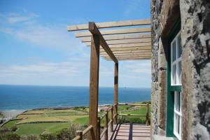 a wooden balcony with a view of the ocean at Moinho da Cascata in Faja Grande