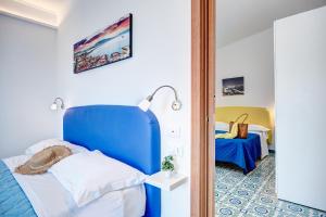 a bedroom with a blue headboard and a bed in a room at Oleum in Massa Lubrense