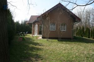 uma pequena casa num quintal com relva em Kápolnai nyaralóház em Balatonoszöd