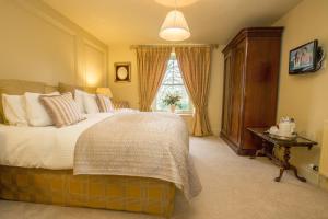 a bedroom with a large bed and a window at The Cornmill in Kirkbymoorside