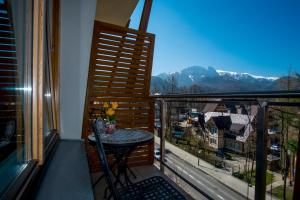 a balcony with a table and a view of the mountains at Aqua Park Residence in Zakopane