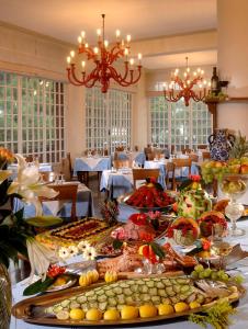 een eetkamer met een tafel vol eten bij Hotel Imperiale in Milano Marittima