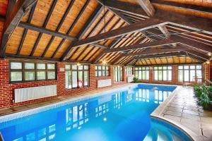 an indoor swimming pool with a wooden ceiling at Felbrigg Lodge in Aylmerton