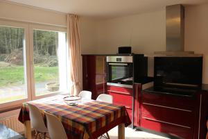 a kitchen with a table and a stove and a table and chairs at Ferienwohnung Huus ton witten Barg in Undeloh +20 photos