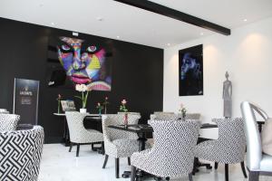 a restaurant with chairs and a painting of a face at Le Dome in Arras